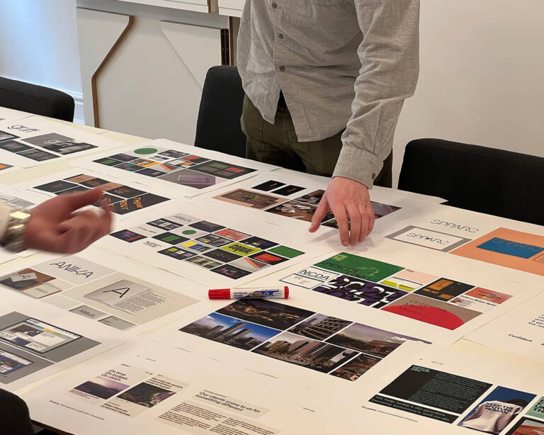 A selection of images laid out on a table are being discussed in a Forty Eight Point One workshop session